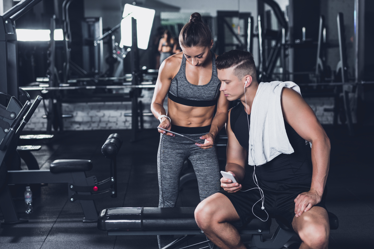 couple using tablet in gym